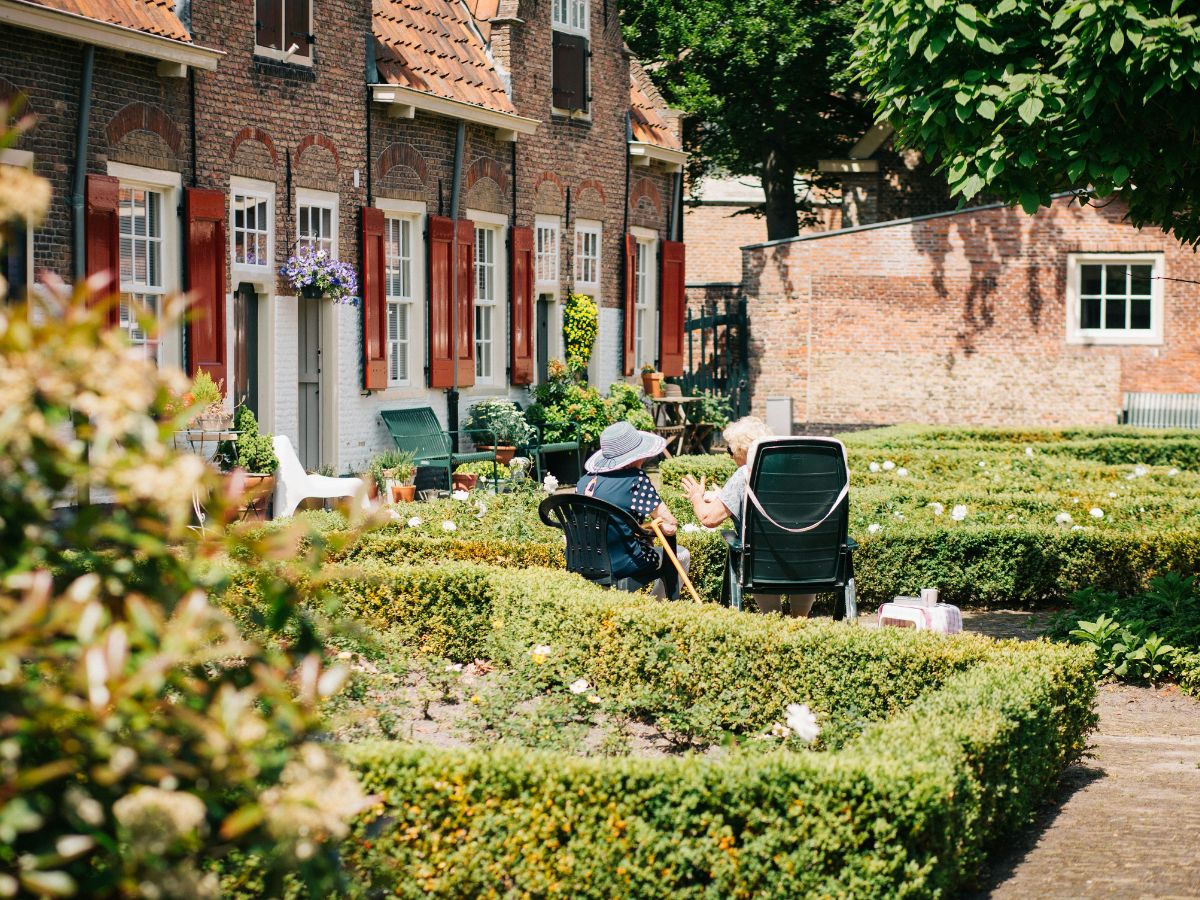 two woman sitting on chair near house at daytime