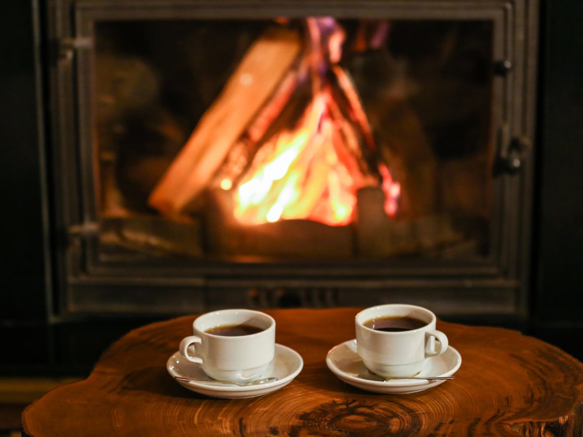 two cups of coffee in front of a fireplace